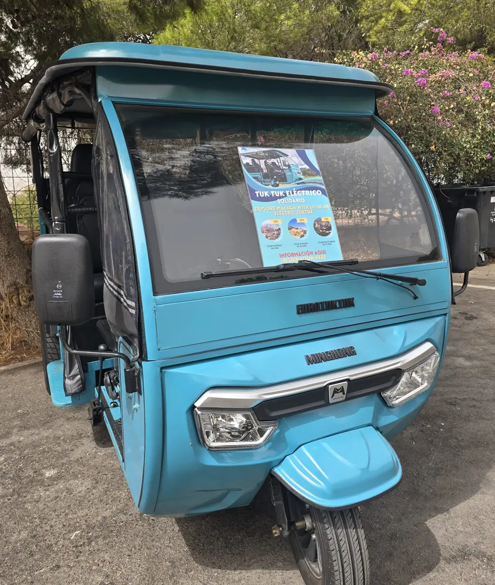 Tuk tuk eléctrico turquesa de EcoMove aparcado en Málaga